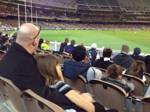 Enjoying a cuddle with Dad at the footy
